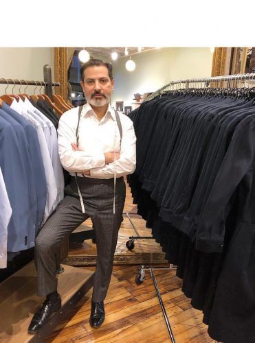 Robinson standing with racks of suits