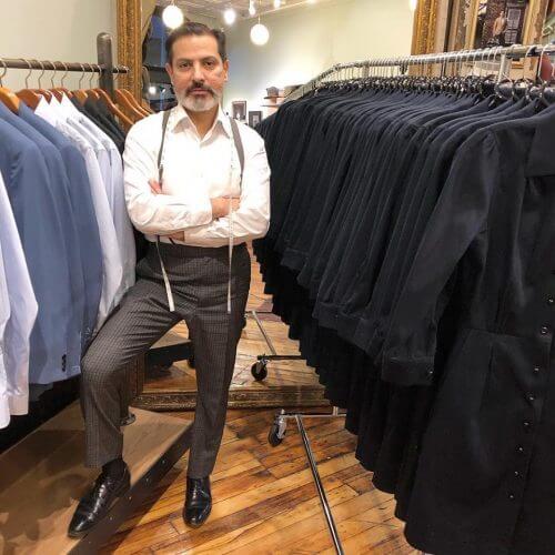 Robinson standing with racks of suits