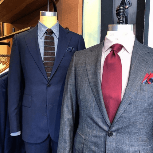Two suits on display, one Navy blue the other Gray