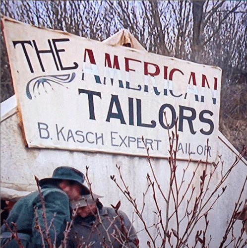 Old photo of a sign saying; "The American Tailors"