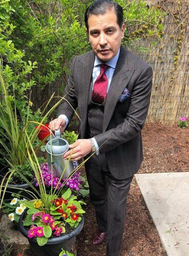 Robinson modeling a suit while watering flowers