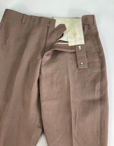 View of pant hooks, zipper and button on light brown dress pants