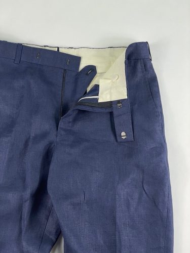 View of pant hooks, zipper and button on blue dress pants