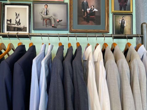 Suit jackets and collared shirts hanging up in the store