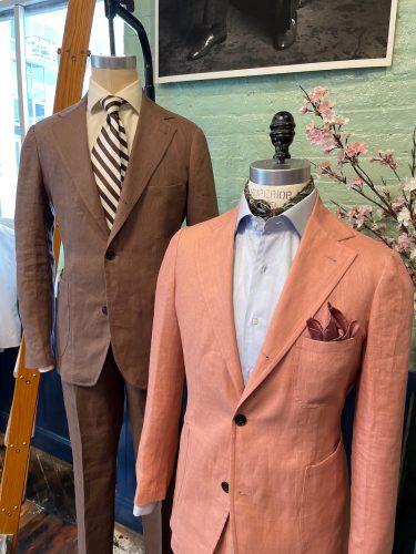 In store display of two suits, one brown and one salmon