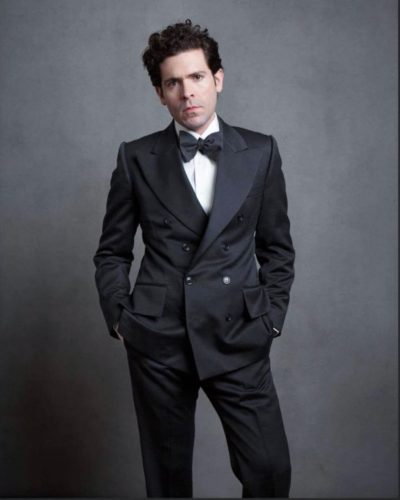 Model showing off a black suit with a black bow tie