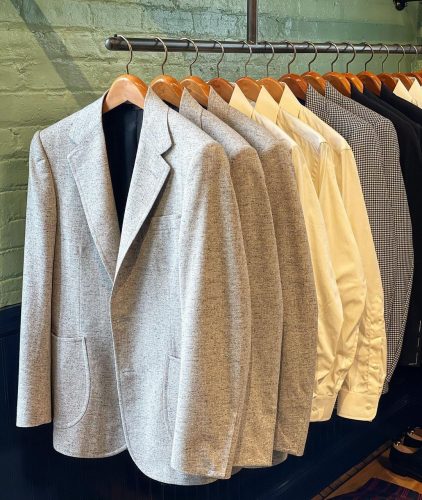 Suit jackets and collared shirts hanging inside the store