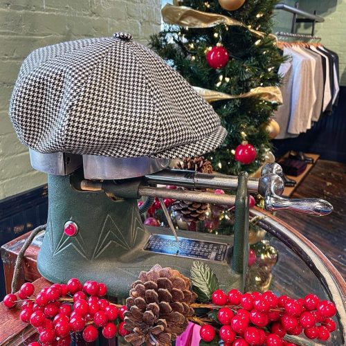 Black and white flat cap displayed among holiday decorations