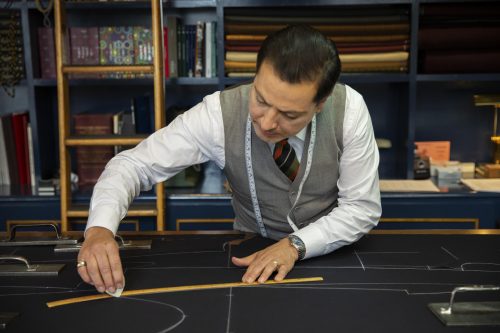 Tailor marking out the suit pattern